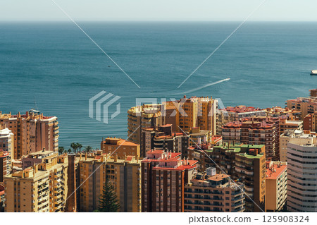 Coastal cityscape with vibrant buildings and a serene sea view. Malaga, Spain Coastal cityscape with vibrant buildings and a serene sea view. Malaga, Spain 125908324