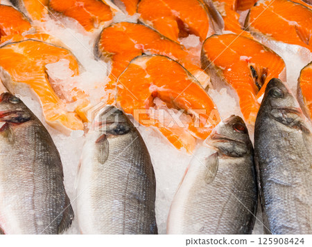 Freshly prepared fish displayed on ice at a vibrant market 125908424