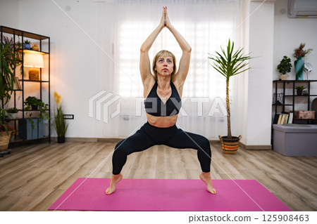 Practicing yoga in a serene indoor space during the day Practicing yoga in a serene indoor space during the day 125908463
