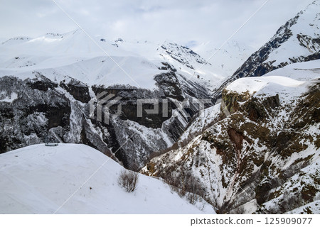 Snowcapped peaks of Caucasus mountains along the Georgian Military Road, major route from Georgia to Russia 125909077