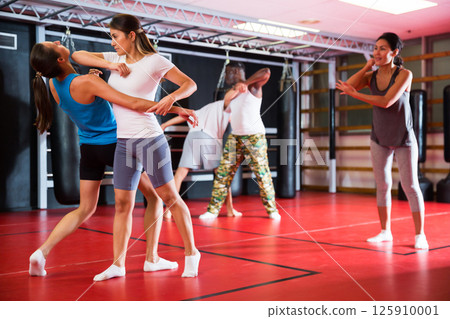 Two woman is training on self defense course in gym 125910001
