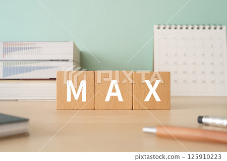 A desk with a block with the word MAX on it A desk with a block with the word MAX on it 125910223