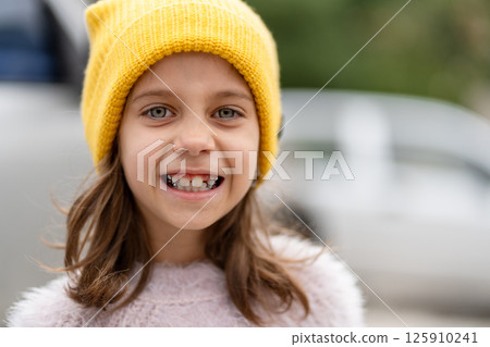 Smiling girl with bright blue eyes in yellow knit Smiling girl with bright blue eyes in yellow knit 125910241
