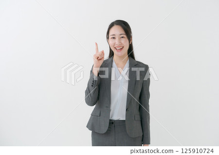 A woman in a suit with her index finger raised A woman in a suit with her index finger raised 125910724