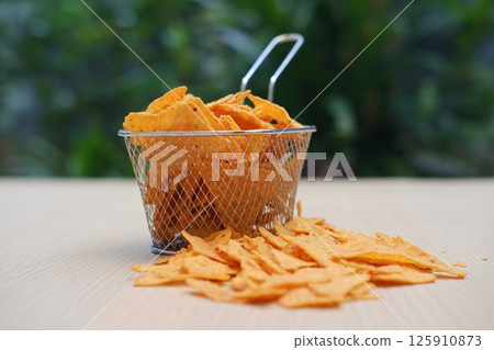 Cheesy Tortilla Chips in Minimalist Setting 125910873