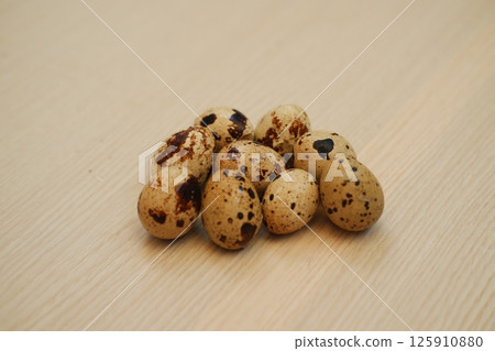 Group of Fresh Quail Eggs on Wooden Surface 125910880