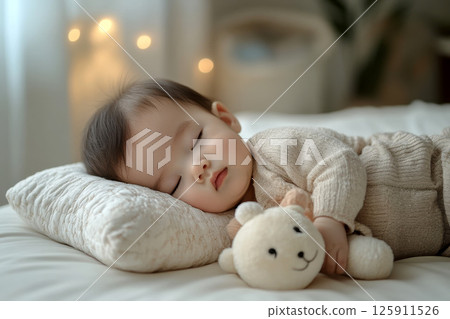 baby sleeping on soft pillow with toy in cozy bedroom. baby sleeping on soft pillow with toy in cozy bedroom. 125911526