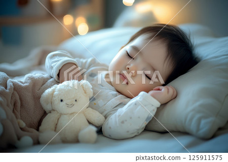 Peaceful Asian baby sleeping on soft pillow with toy in cozy bedroom. Peaceful Asian baby sleeping on soft pillow with toy in cozy bedroom. 125911575