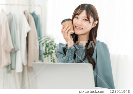 年輕的亞洲女商人在辦公室喝咖啡 年輕的亞洲女商人在辦公室喝咖啡 125911948