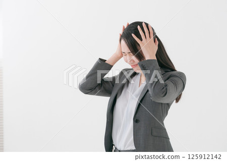 A woman in a suit with a worried expression A woman in a suit with a worried expression 125912142