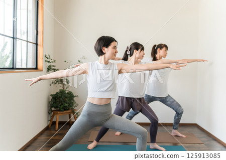 Women learning yoga in yoga class/pilates Women learning yoga in yoga class/pilates 125913085