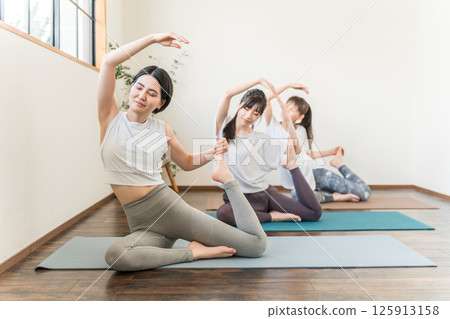 Women who do yoga and pilates in yoga studios and yoga classes (sports gym) 125913158