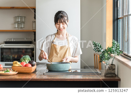 年輕的亞洲女性在廚房做飯（烹飪/家庭烹飪） 125913247