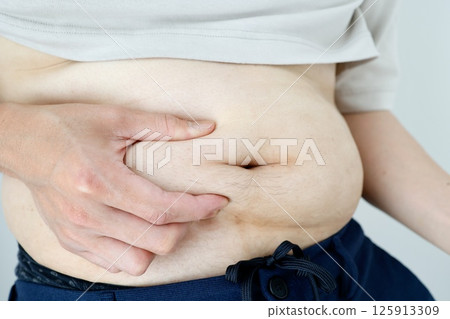 Obese man pinching his stomach 125913309