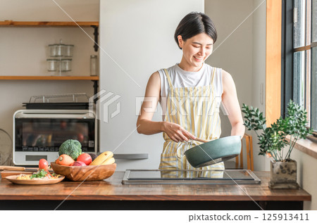 年輕的亞洲女性在廚房做飯（烹飪、家常菜、炒菜） 125913411