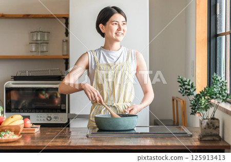 年輕的亞洲女性在廚房做飯（烹飪、家常菜、炒菜） 125913413