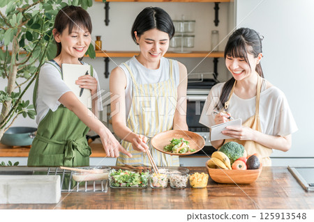 A female instructor and female students teaching cooking at a cooking class/cooking school A female instructor and female students teaching cooking at a cooking class/cooking school 125913548