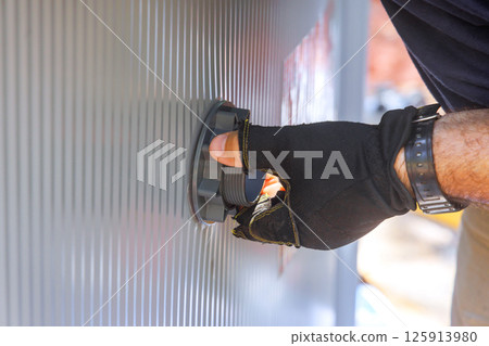 Worker in gloves is securing valve filtration system to swimming pool at backyard 125913980