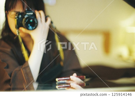 A woman taking a picture with a camera A woman taking a picture with a camera 125914146