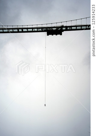 Bungee Jump from a Bridge Under Cloudy Sky 125914233