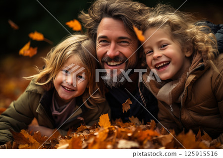 Father and his two children outdoor in autumn leaves. 125915516
