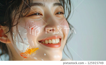portrait of a smiling young woman with painted face, a cheerful young woman with colorful paint on her face, natural lighting, and bright smile, Perfect for themes of joy, creativity, youth, beauty 125915749