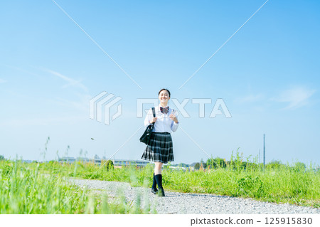High school girls walking under the blue sky 125915830