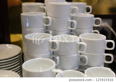 Neatly stacked white cups add a cozy vibe 125915910