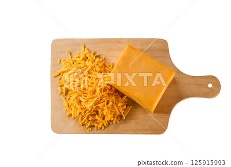 grated cheddar cheese on a cutting board isolated on a white background, top view. grated cheddar cheese on a cutting board isolated on a white background, top view. 125915993