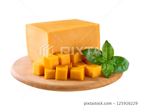 diced cheddar cheese with green basil on cutting board isolated on white background. 125916229