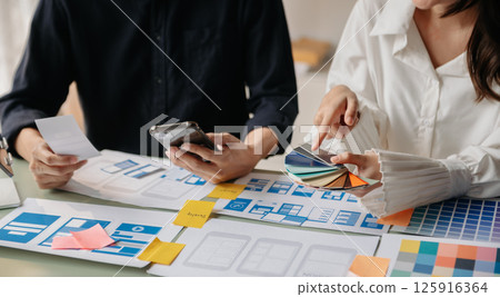 Close up view of UI developer team brainstorming on their project with laptop, smartphone and digital tablet. Creative digital development. Close up view of UI developer team brainstorming on their project with laptop, smartphone and digital tablet. Creative digital development. 125916364