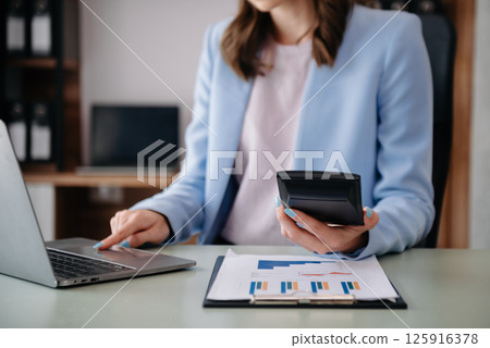 Hand business doing finances and calculate on desk about cost using on smartphone and tablet as concept Hand business doing finances and calculate on desk about cost using on smartphone and tablet as concept 125916378