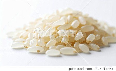 Japanese rice grains scattered on a white background, showcasing their detailed shape and texture, grains and is suitable for culinary, agricultural, food industry contexts, rice texture 125917263