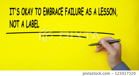 It is okay to embrace failure as a lesson, not a label text written on yellow cover background. Inspirational and motivational concept. 125917320