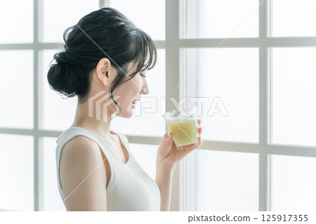 Asian woman who doesn't like vegetables drinking green smoothie at home (can't drink, not good at it, troubled, worried) Asian woman who doesn't like vegetables drinking green smoothie at home (can't drink, not good at it, troubled, worried) 125917355