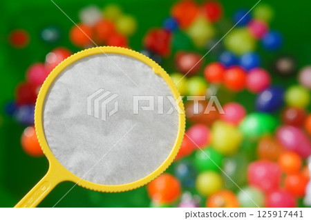An elementary school child enjoys scooping a ball in the garden. Poi from the super ball scoop. 125917441