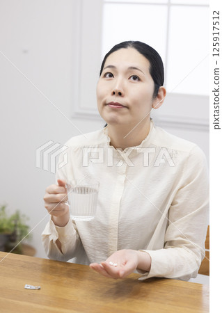 Woman taking medicine Woman taking medicine 125917512