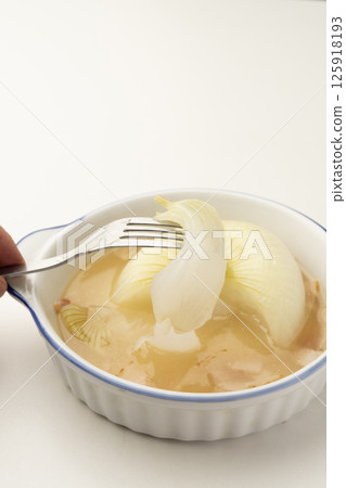 用叉子將洋蔥從燉好的新洋蔥湯中取出 125918193