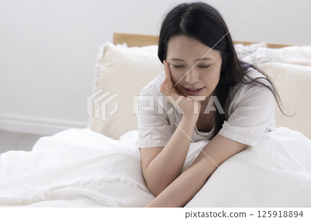 A woman daydreaming in bed 125918894