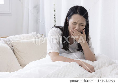 一個女人在床上打哈欠 125918895
