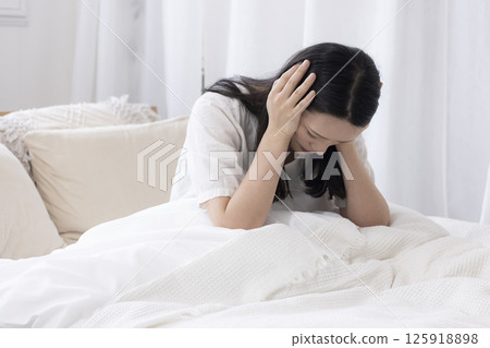 女人在床上抱著頭 125918898