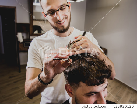 Young man with trendy haircut at barber shop. Young man with trendy haircut at barber shop. 125920129
