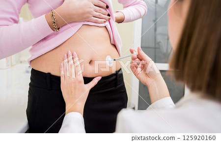 Doctor makes an injection of insulin with a catheter. Doctor makes an injection of insulin with a catheter. 125920160