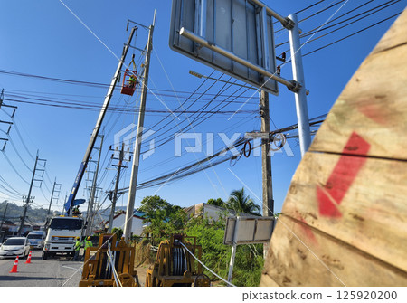 Installation of high-voltage electric wires on new poles along the road Installation of high-voltage electric wires on new poles along the road 125920200