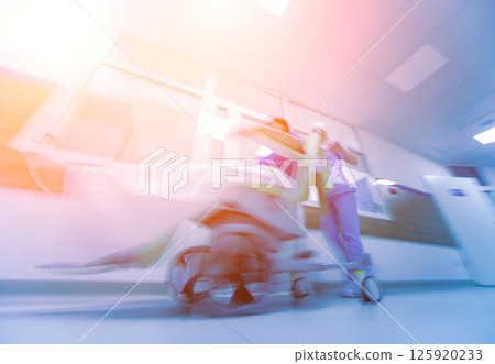 Nurse moves mobile medical chair with patient at hospital. Medical equipment. 125920233