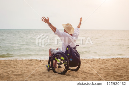 Disabled man in a wheelchair on the beach. Disabled man in a wheelchair on the beach. 125920482