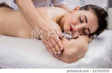 Beautiful young woman enjoying massage in spa salon. Cosmetology Beautiful young woman enjoying massage in spa salon. Cosmetology 125920550