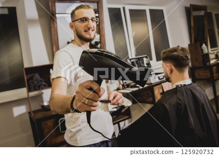 Young man with trendy haircut at barber shop.  125920732