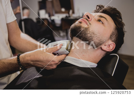 Young man with trendy haircut at barber shop.  125920753