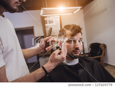 Young man with trendy haircut at barber shop.  125920779